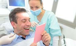 dental patient admiring his smile in mirror