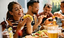 Woman smiling while eating lunch with friends at restaurant