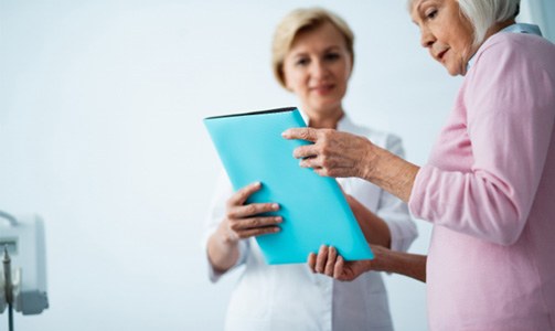 Senior woman learning about tooth replacement treatment options