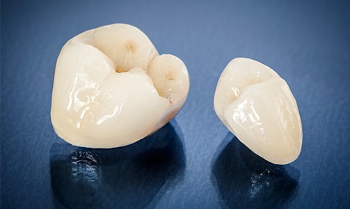 Two dental crowns against blue background