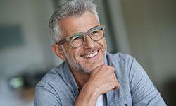 elderly man with glasses smiling