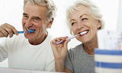 elderly couple brushing their teeth