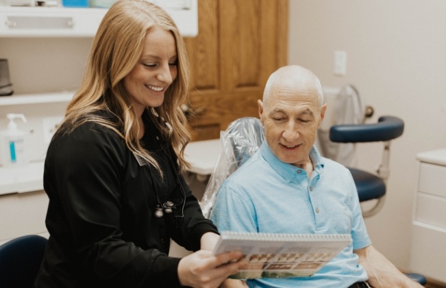 Senior man in dental chair smiling at Doctor Cline