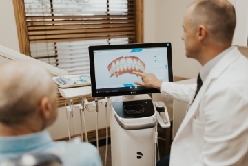 Young woman in pale pink tee shirt smiling in dental chair