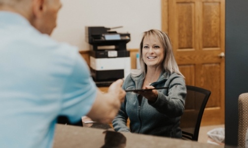 Patient checking in at dental office reception desk