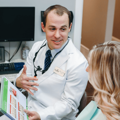 Doctor Cline showing a dental patient informational paperwork