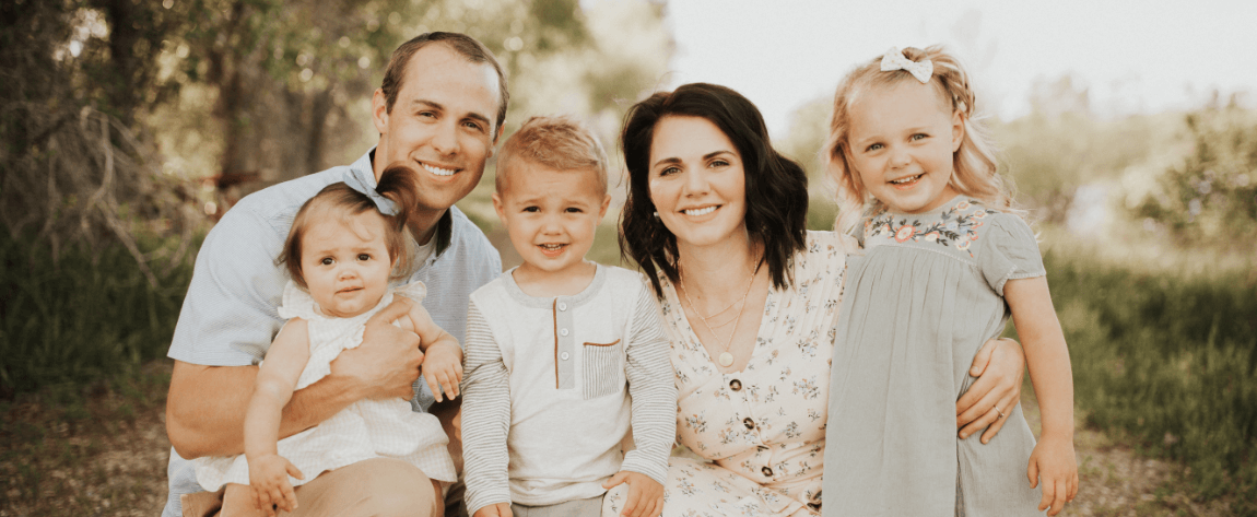 Doctor Cline and his family smiling in forest