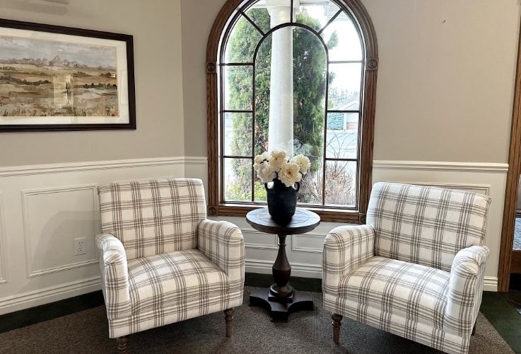 Two black and white plaid armchairs in waiting area