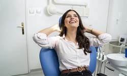 Woman smiling and looking relieved in dental chair