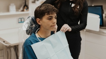 Man in dental chair smiling with dentist