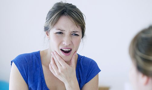 Dental patient holding their jaw in pain