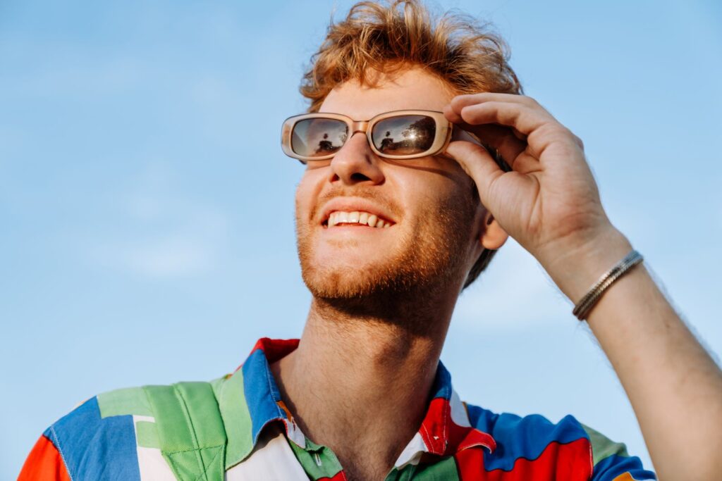 A man in sunglasses smiling in the sun.